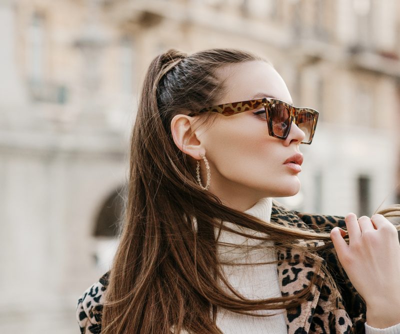 Stylish woman wearing polarized sunglasses outdoors, showcasing glare reduction, eye comfort, and enhanced visual clarity benefits - are polarized sunglasses worth it
