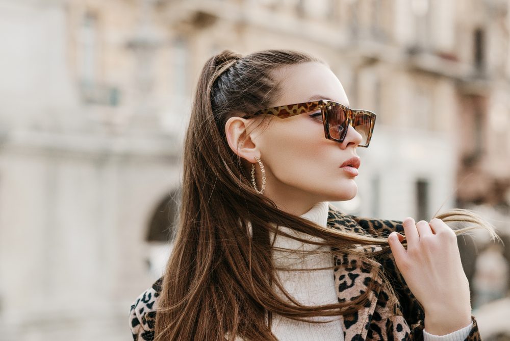 Stylish woman wearing polarized sunglasses outdoors, showcasing glare reduction, eye comfort, and enhanced visual clarity benefits - are polarised sunglasses worth it