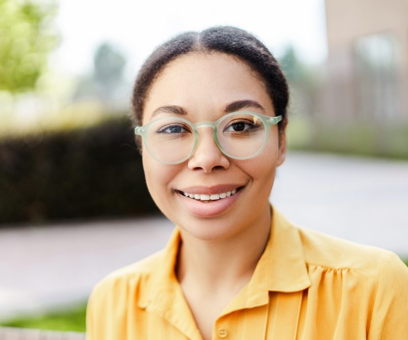 Woman wearing modern eyeglasses outdoors, representing vision correction updates and signs of a significant change in eyeglass prescription - what is a significant change in eyeglass prescription
