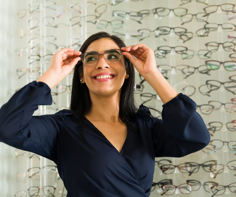 Woman adjusting eyeglasses to show correct fit, alignment, and comfort for everyday wear and clear vision - how glasses should fit on your face