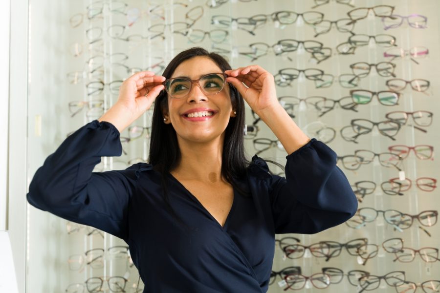Woman adjusting eyeglasses to show correct fit, alignment, and comfort for everyday wear and clear vision - how glasses should fit on your face